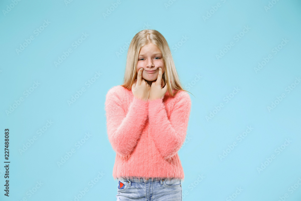Why is that. Beautiful female half-length portrait on trendy blue studio backgroud. Young emotional surprised, frustrated and bewildered teen girl. Human emotions, facial expression concept. Why is that. Beautiful female half-length portrait on trendy blue studio backgroud. Young emotional surprised, frustrated and bewildered teen girl. Human emotions, facial expression concept.