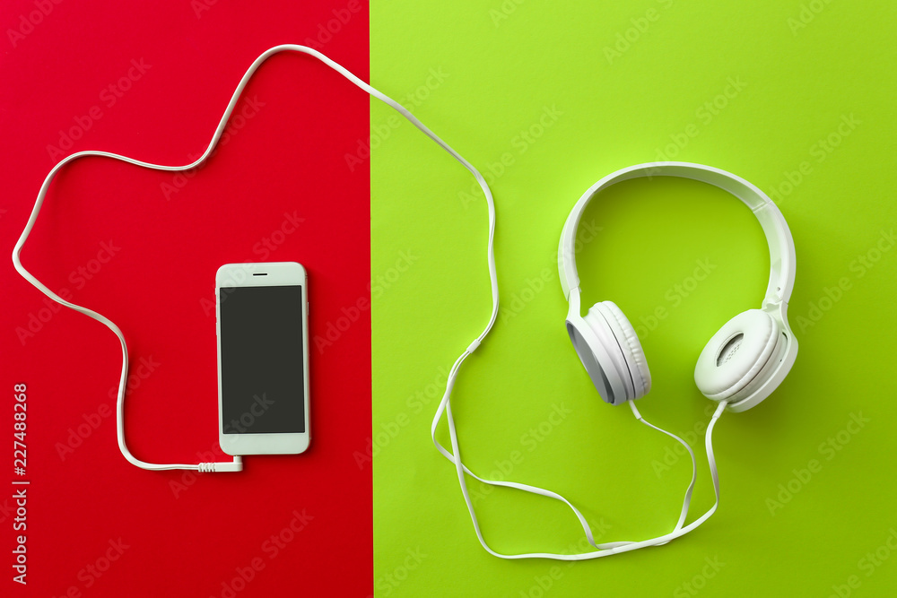 Mobile phone with headphones on color background Mobile phone with headphones on color background
