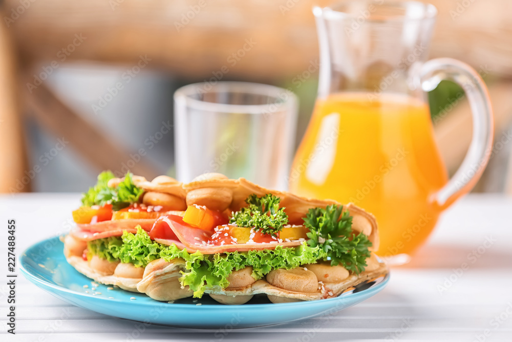 Plate with delicious bubble waffle on white wooden table