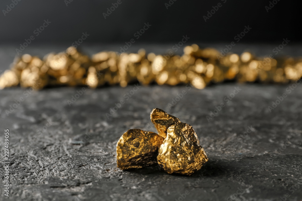 Gold nuggets on dark table Gold nuggets on dark table