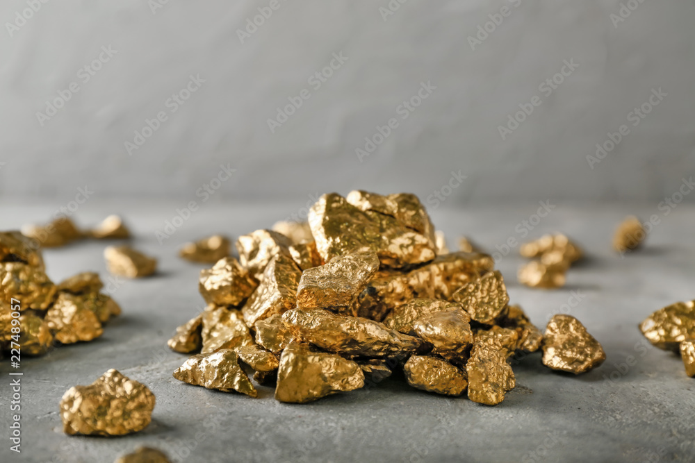 Gold nuggets on grey table Gold nuggets on grey table