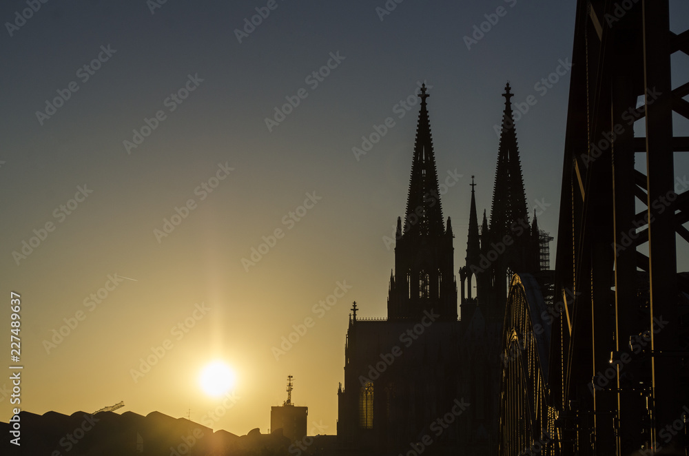 Sun Setting behind a Cathedral by a Bridge