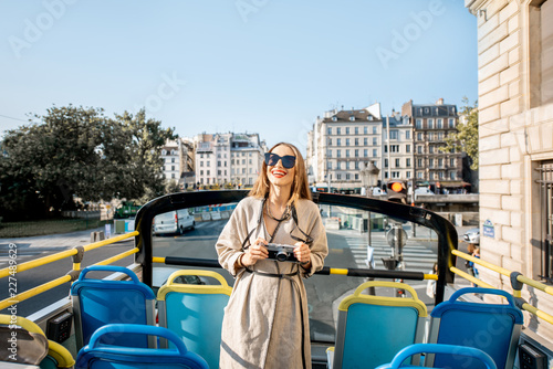 Young woman enjoying a beautiful view on the city during a bus tour in Paris, France