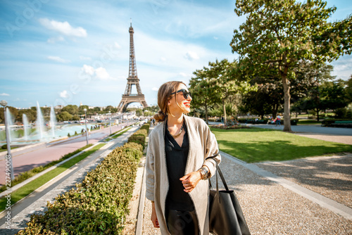 Photography Lifestyle portrait of a young woman walking in front of the famous Eiffel tower