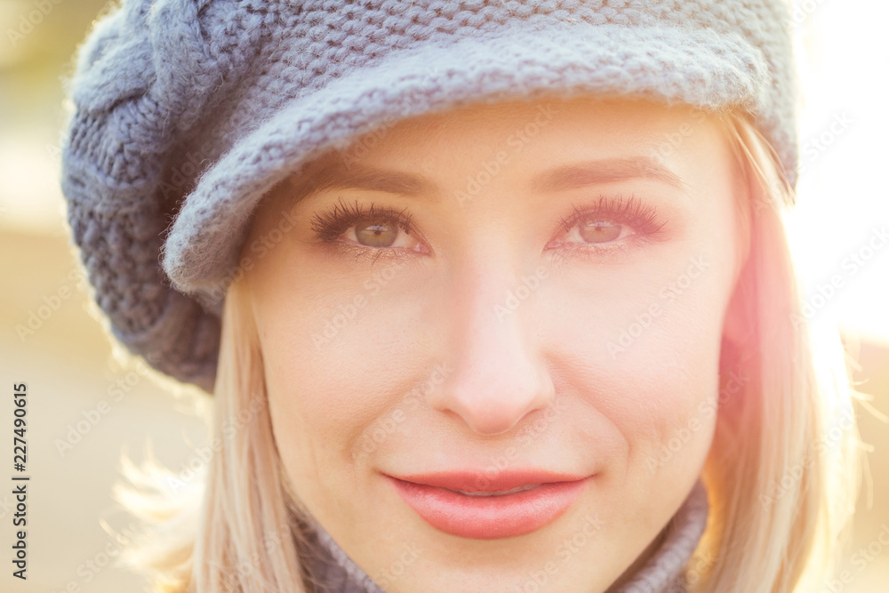 Young blonde happy smiling naive glance woman in French blue beret coat and warm hat outdoor closeup portrait perfect skin and day makeup in the autumn park. Cold outside. Winter spring clothes Young blonde happy smiling naive glance woman in French blue beret coat and warm hat outdoor closeup portrait perfect skin and day makeup in the autumn park. Cold outside. Winter spring clothes