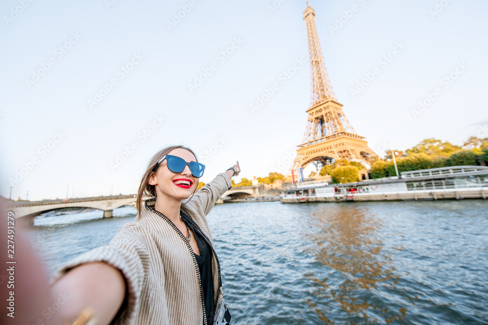 Young woman tourist making selfie photo with Eiffel tower on the background  from the boat during the sunset in Paris Stock Photo | Adobe Stock