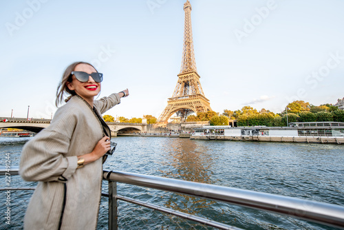 Young woman enjoying beautiful landscape view on the riverside with Eiffel tower from the boat during the sunset in Paris © rh2010