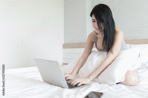 woman and laptop shopping online internet on weekend Halliday in the ;white bedroom 
