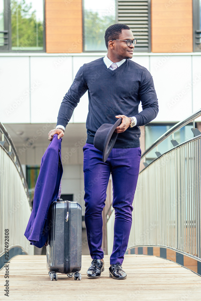Young businessman after arriving. Comfortable airport, work trip, business  lifestyle. African-american male model with luggage after coming to end  point of his trip. Leaving terminal with documents Stock Photo - Alamy