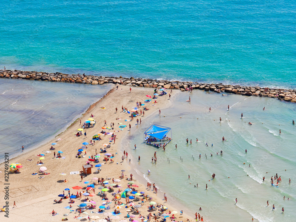 Beautiful beach and sunbathers and the mediterranean sea in Alicante. Spain.