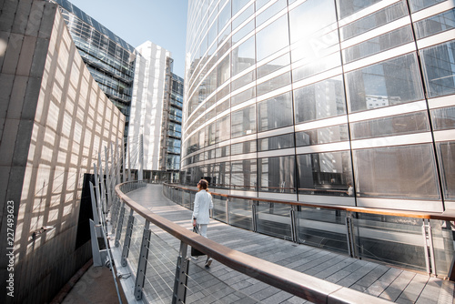 Business woman walking outdoors at the financial district with modern buildings on the background in Paris