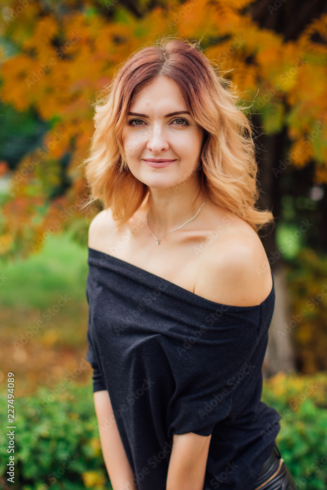 Charming woman in a black dress in the autumn park Charming woman in a black dress in the autumn park