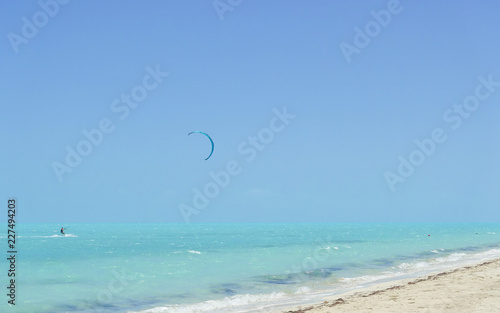 A kiteboarder surfs along the turquoise water on Long Bay Beach, Providenciales, Turks and Caicos