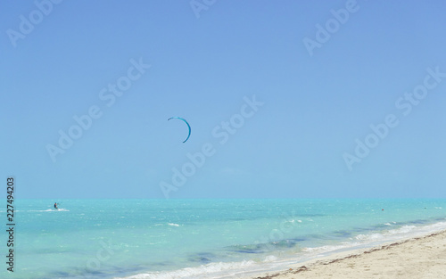 Photography A kiteboarder surfs along the turquoise water on Long Bay Beach, Providenciales,