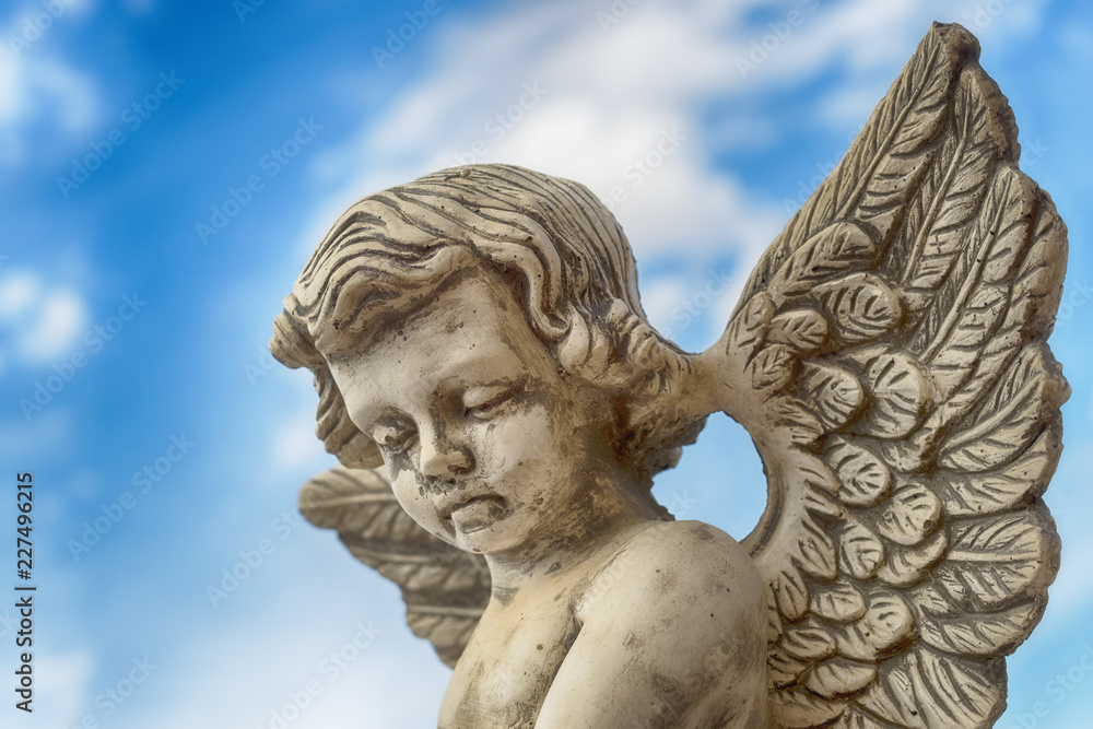 statue of angel on white background of sky