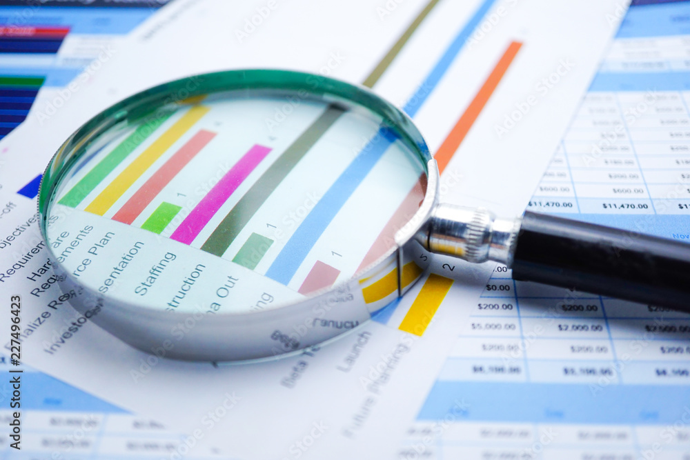 Magnifying glass on charts graphs spreadsheet paper. Financial development, Banking Account, Statistics, Investment Analytic research data economy, Stock exchange trading, Business office company meet Magnifying glass on charts graphs spreadsheet paper. Financial development, Banking Account, Statistics, Investment Analytic research data economy, Stock exchange trading, Business office company meet