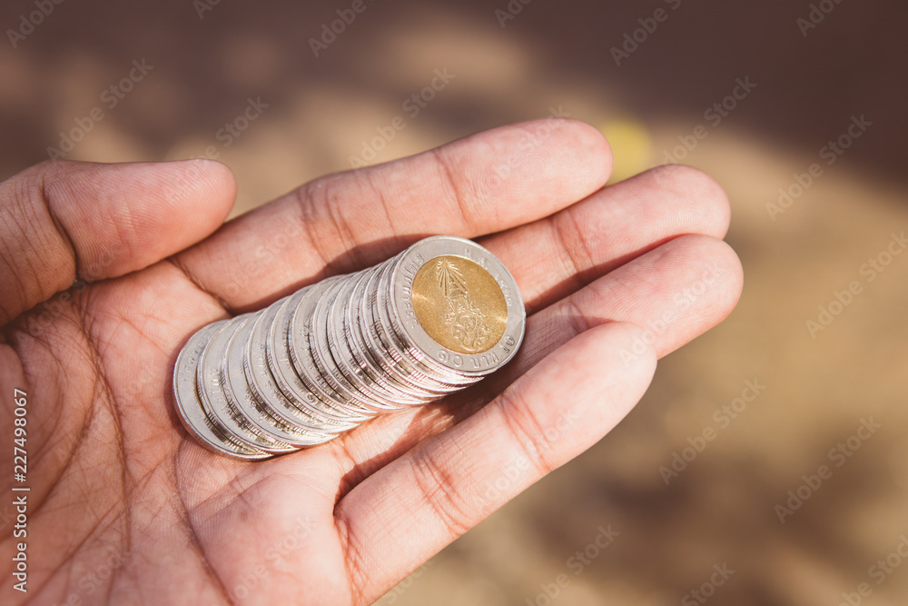 Fototapeta premium Closeup stack coins of Thai baht on hand