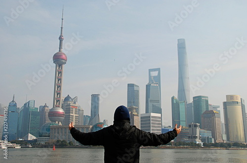 A man enjoying panorama of Shanghai modern skyscrapers from The Bund, China