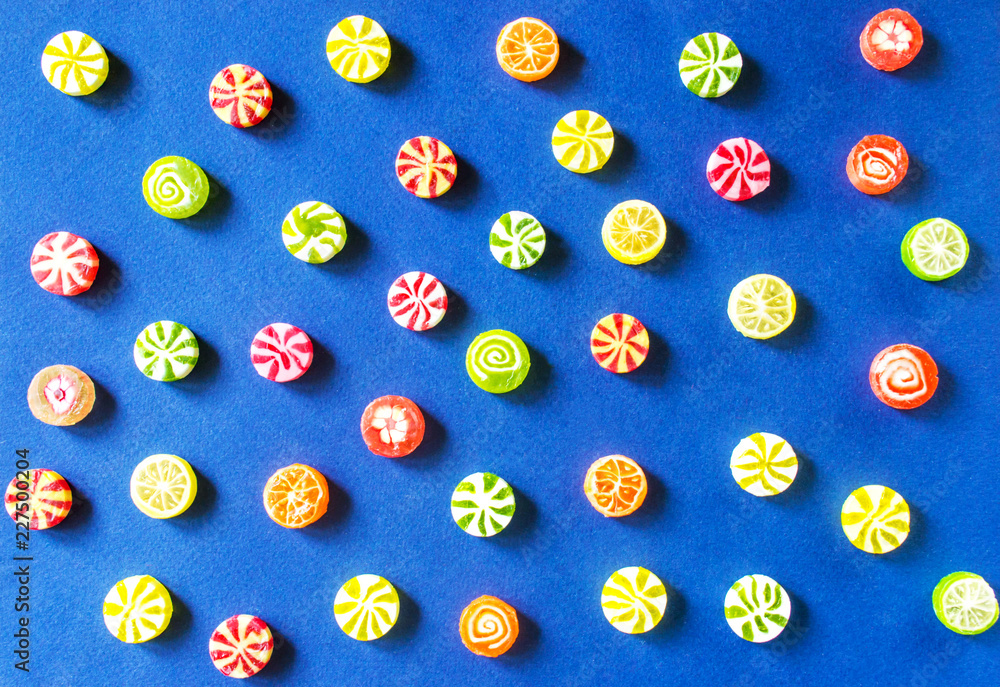 Multicolored caramel candies on a blue background Multicolored caramel candies on a blue background