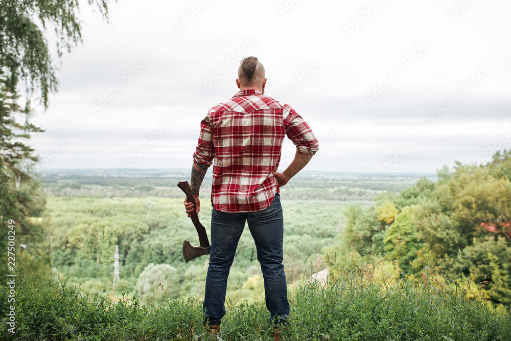 Ταπετσαρία Rear back view of lumberjack in forest holding an axe on his shoulder