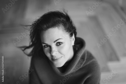 Young beautiful smiling woman in warm sweater enjoying time at home. Happy life  mental health  balance and restore concept. Black and white photo.
