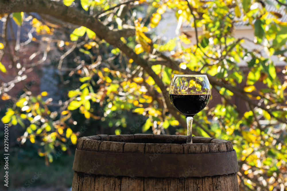 Fototapeta premium Red Wine Bottle and Wine Glass on Wodden Barrel