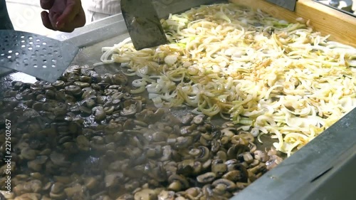 Saut√©ed Onions and Mushrooms Cooking on a Hot Commercial Stainless Steel Griddle photo