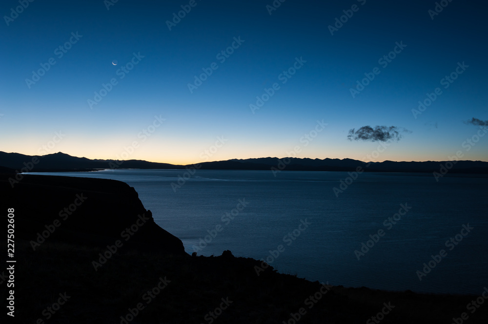Sacred lake and mountain of Tibet during dawn with crescent moon