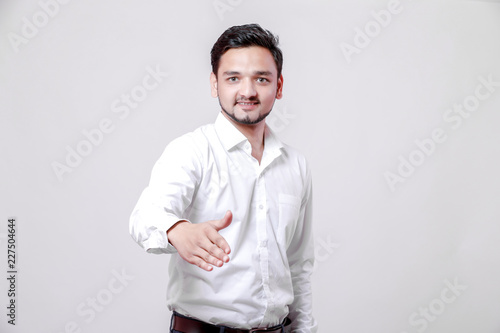 young indian man making a deal over isolated white background
