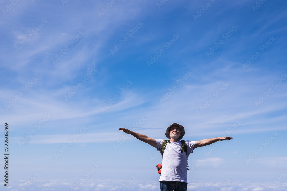Adult white beard senior retired free man enjoy freedom and independence during a backpack vacation trip adventure. alternative lifestyle discovering the world. blue sky in background Adult white beard senior retired free man enjoy freedom and independence during a backpack vacation trip adventure. alternative lifestyle discovering the world. blue sky in background
