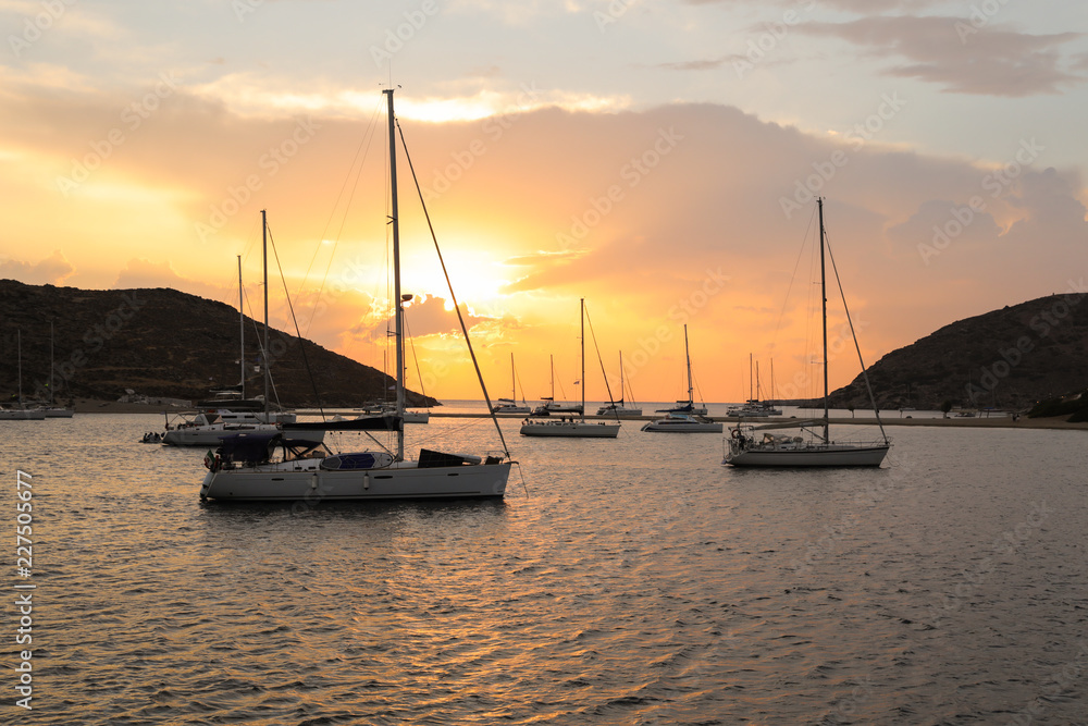 Beautiful sunset and sailboats in Kolona double bay Kythnos island Cyclades Greece.