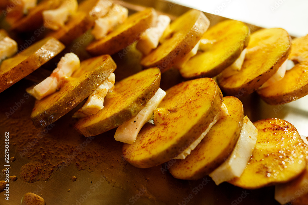 Sliced potatoes with bacon on a skewer Sliced potatoes with bacon on a skewer