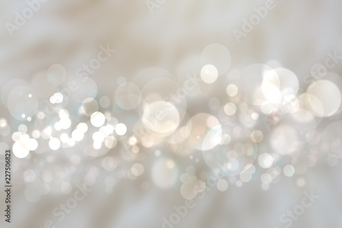 Abstract silver background texture with blurred white bokeh light circles.