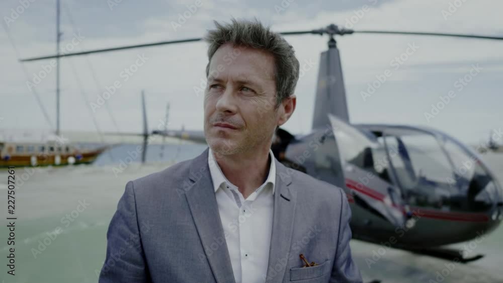 Businessman waiting near private helicopter Businessman waiting near private helicopter