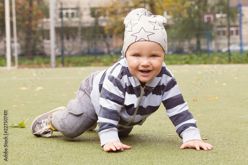 Smiling child playing outdoors, little boy 1-2 years old