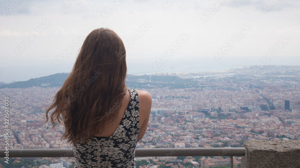 Girl staying on observation deck. Barcelona city aerial view. City overview. Breathtaking view