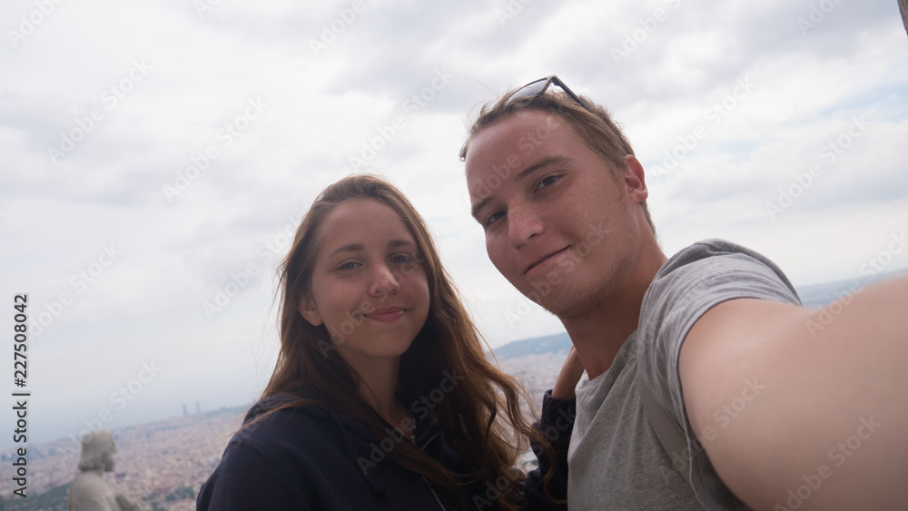 A young couple taking a selfie on observation deck. Barcelona city aerial view. City overview.