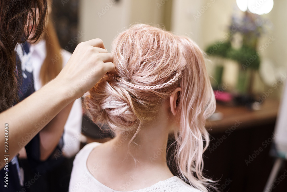 Naklejka premium Hairdressing services.Сreating an evening hairstyle. Hair styling process.