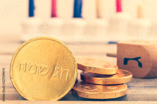 Close up of Hanukkah gelt or coins. Translation of the hebrew text: Happy Holidays and Letter G photo