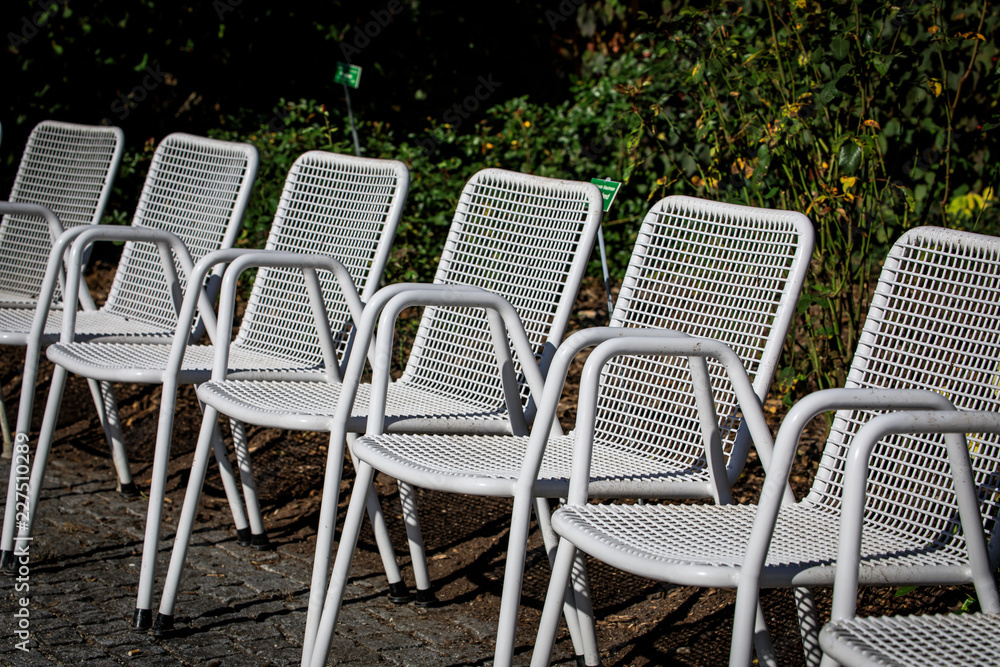 Weiße Stuhlreihe im Park