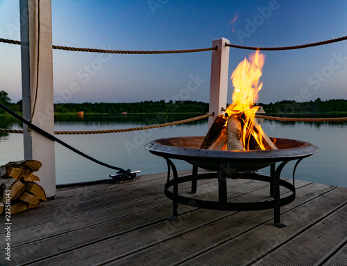 Feuer in einer Feuerschale am Abend am See photo