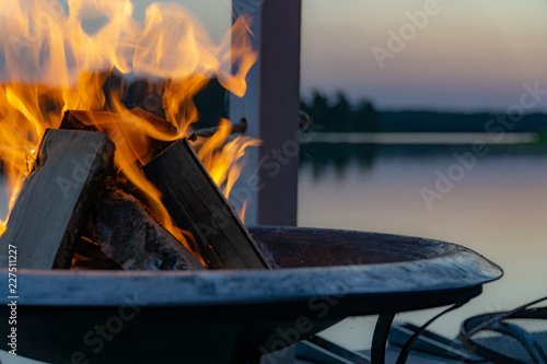 Flammen in einer Feuerschale in der Dämmerung am See photo