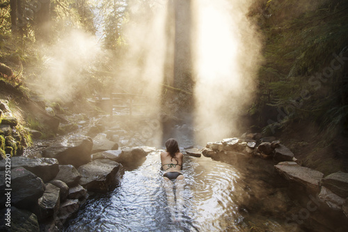 Woman relaxing in hot spring at forest
