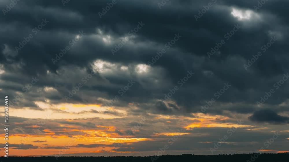 Sunset Sky. Bright Dramatic Sky With Fluffy Clouds. Yellow, Orange, Blue And Magenta Colours. Time Lapse Time-lapse Sunset Sky. Bright Dramatic Sky With Fluffy Clouds. Yellow, Orange, Blue And Magenta Colours. Time Lapse Time-lapse