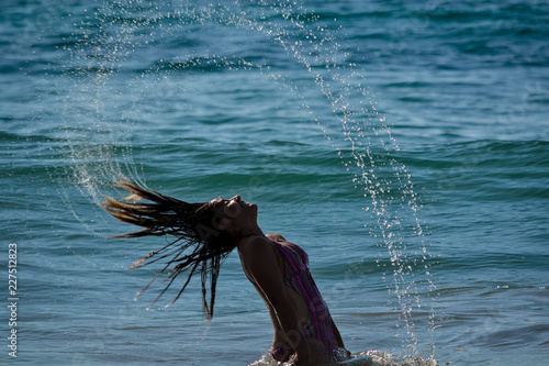 pretty woman playing with water on the beach