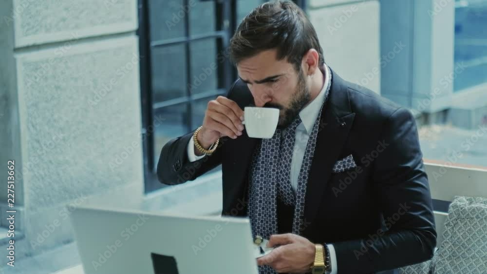 Focused businessman working on a laptop and drinking coffee Focused businessman working on a laptop and drinking coffee