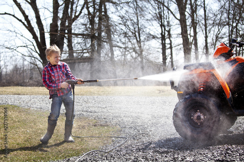 Photography Boy washing quadbike in field