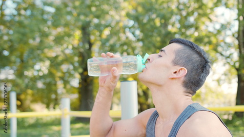 Caucasian Man Drinking Water with His Eyes Closed After Exercises
