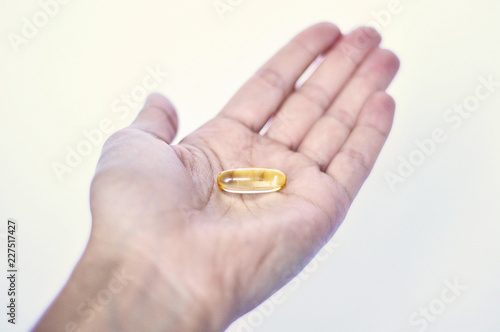 fish oil pills. Omega 3. skin care. skin health. pills on white background. women Health. yellow pills. fish fat. medicine.