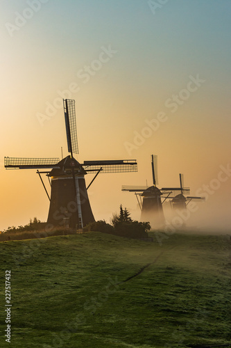 Three wind mills of Molendriegang Leidschendam, Netherlands during a misty Sunrise